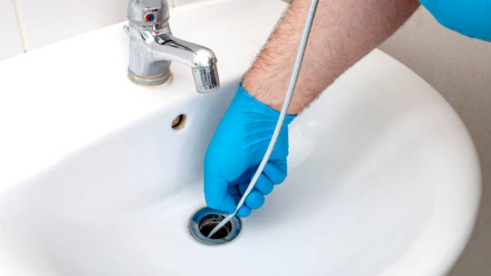 Feeding the Plumbing Snake into the Drain