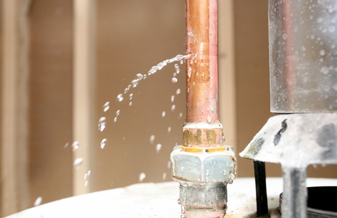 Water is leaking out of a pipe on top of a water heater